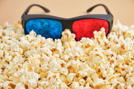 Glasses buried in a pile of popcorn, cinema concept. watching movies in the cinema in 3D formatの写真素材