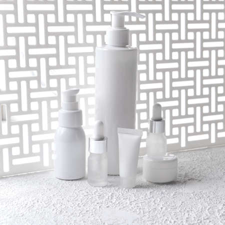 Set of Different cosmetic bottles of cream or lotion. beauty product mock up against of a geometric screen with natural light and shadow. Blank packaging. Natural beauty spa product concept. Mock-upの写真素材