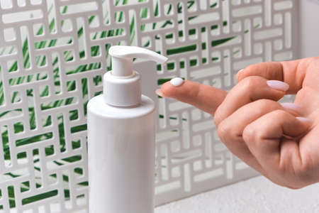 Body Lotion Skin Care Apply. women hands holding body cream pump bottle. Beauty And Body Care...