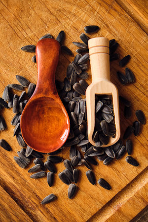 sunflower seeds and oil in wooden spoon on wood backgroundの写真素材