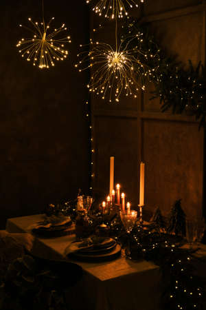 Beautiful, decorated table with flower decorations, candles and led lights. Christmas evening or wedding party decoration.の写真素材