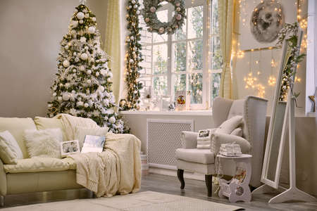 Bright living room decorated for the new year and christmas with decor and lights, a beautiful treeの写真素材
