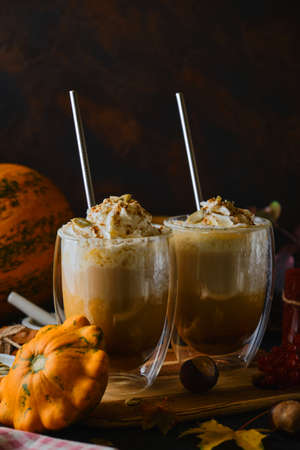 Pumpkin latte with whipped cream in a glasses in the style of dark food. Autumn Hot spicy drink for Halloween or Thanksgiving. selective focusの写真素材