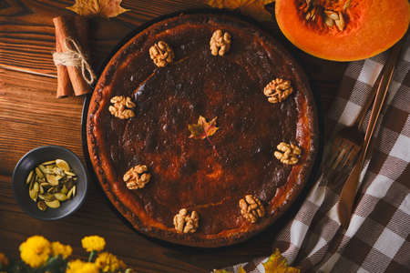 Traditional Pumpkin pie Gluten-free with walnuts and ingredients for cooking on a wooden table. Autumn food in dark style, top viewの写真素材