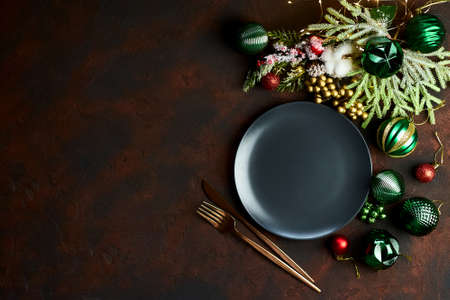 Christmas table setting with black empty plate and xmas decor. Top view flat lay with copy spaceの写真素材