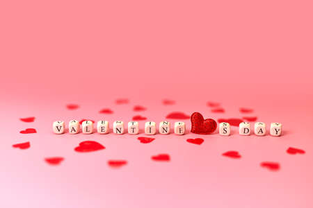 The word Valentine's Day and red hearts. Love on wooden blocks. love theme. Wooden beads for letters. Love, positive emotions. Wooden cubes with letters.の写真素材