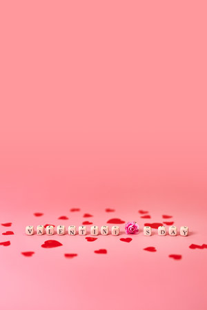 The word Valentine's Day, flower and red hearts. Love on wooden blocks. love theme. Wooden beads for letters. Love, positive emotions. Wooden cubes with letters.の写真素材