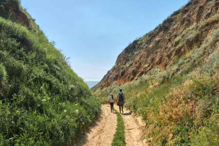 Father and daughter hikers walking in the green hills. goal, success, freedom and travel conceptの写真素材