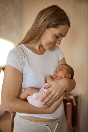 Mother holding her newborn baby in hands. The baby on hands at mum. Loving mother hand holding cute newborn baby childの写真素材