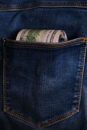 Jeans pocket with money, close-up. Blue jeans pocket with hundred dollars banknotesの写真素材