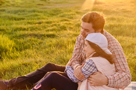 A happy father is having fun with his little daughter in nature, the daughter is hugging her dad and smiling.の写真素材