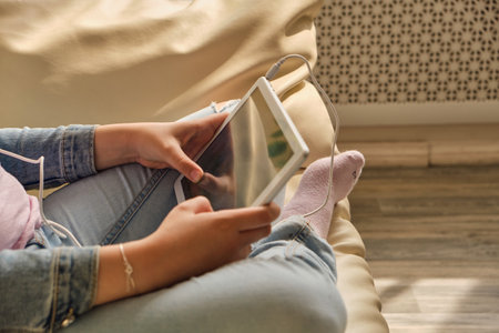 Cute little girl in casual clothes using a tabletの写真素材