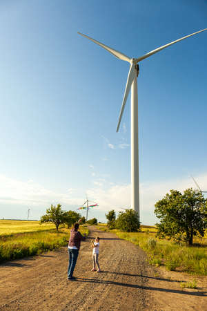 Father and daughter having fun, playing with kite together on the Wheat Field on Bright Summer dayの写真素材