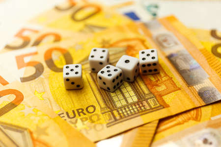 White Gaming dice and money on dark table.の写真素材