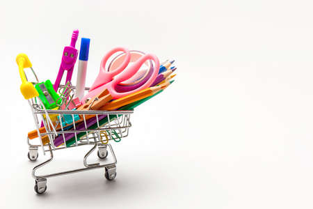 Shopping trolley filled with multicolored school supplies i