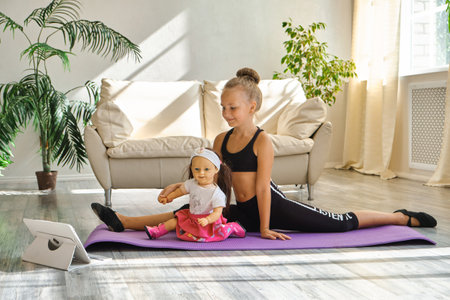 Kid repeating exercises while watching online yoga gymnastics sessionの写真素材