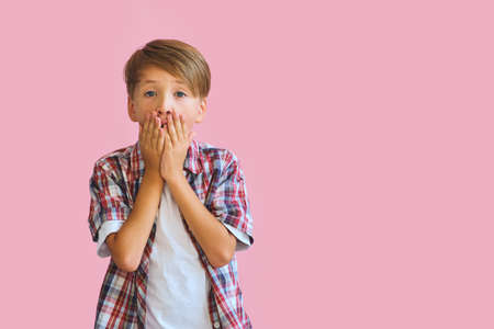 Young happy teen boy with in casuals on pink background.の写真素材