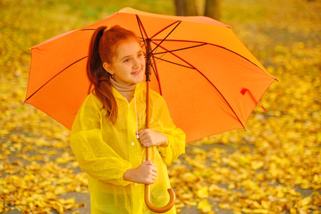 happy kid catching rain drops in Autumn parkの写真素材