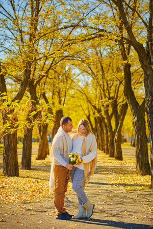 Pregnant woman and man at sunny warm autumn parkの写真素材