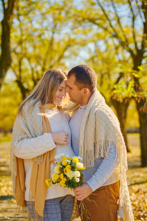 Pregnant woman and man at sunny warm autumn parkの写真素材