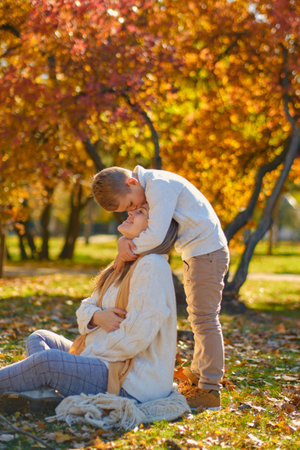 little son hugs his pregnant mom on the natureの写真素材