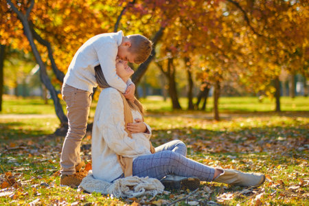 little son hugs his pregnant mom on the natureの写真素材