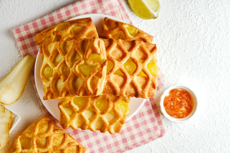 puff pastry mini pies with with pear and lime jam filling on a white plateの写真素材