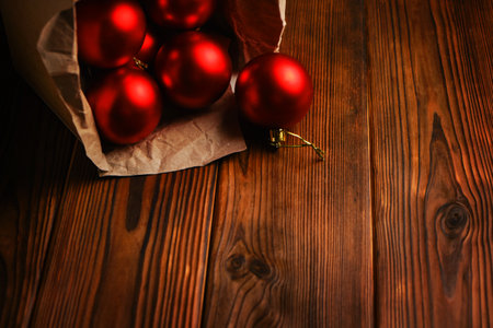 Red christmas balls in a box on a wooden tableの写真素材