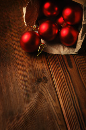 Red christmas balls in a box on a wooden tableの写真素材