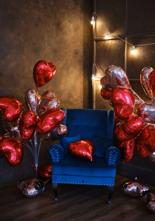 blue armchair decorated with lots of heart shaped balloonsの写真素材