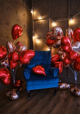 blue armchair decorated with lots of heart shaped balloonsの写真素材