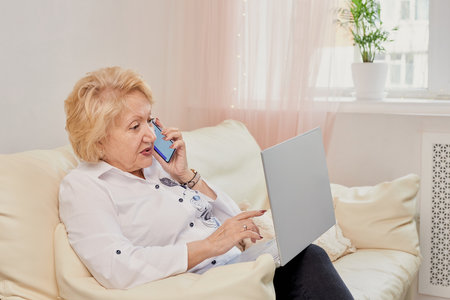 Smiling senior woman having conversation on phoneの写真素材