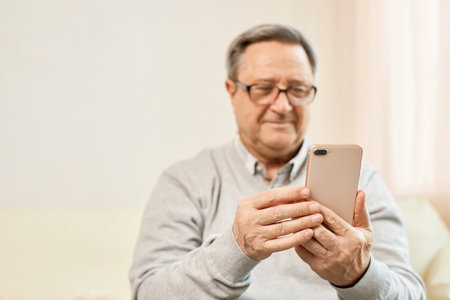 Portrait of smiling mature man using mobile phoneの写真素材