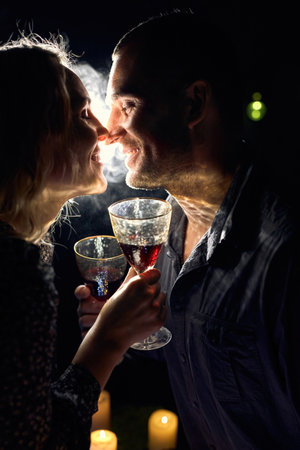 Romantic Couple with Wine Glasses and Candlesの写真素材