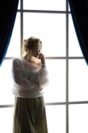 Stylish young woman in modern interior in the contrasting lightの写真素材