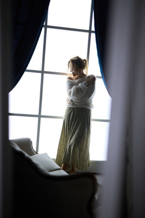 Stylish young woman in modern interior in the contrasting lightの写真素材