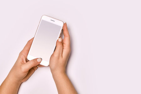 Female hands holding modern cellphone.の写真素材