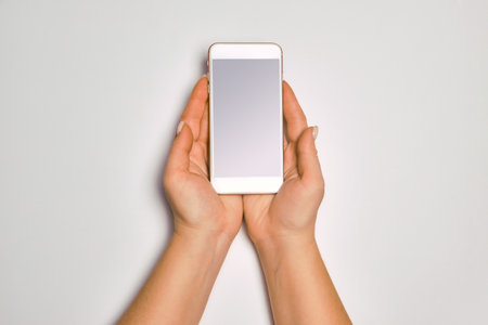 Female hands holding modern cellphone.の写真素材