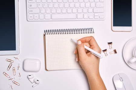 Woman writing on empty list in notepad to do list.の写真素材