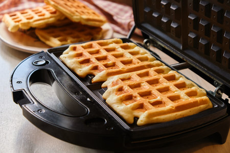 waffles are baked waffle iron machine. Belgian waffle dessert.の写真素材