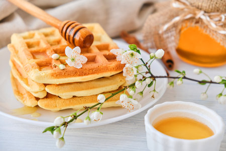 Honey pouring on a fresh Belgian waffles.の写真素材