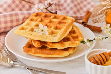 Honey pouring on a fresh Belgian waffles.の写真素材