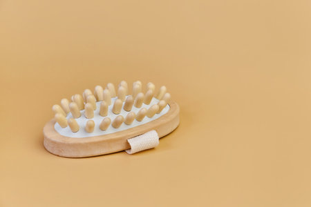 wooden massage brush with natural bristles on beige backgroundの写真素材