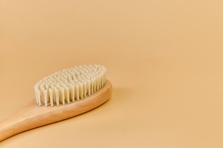 wooden massage brush with natural bristles on beige backgroundの写真素材