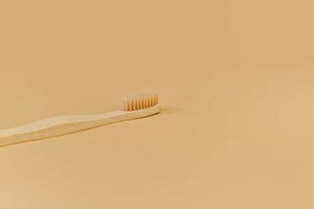 Single Bamboo wooden toothbrushe on beige background.の写真素材