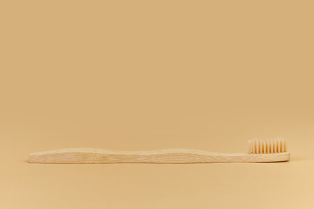 Single Bamboo wooden toothbrushe on beige background.の写真素材