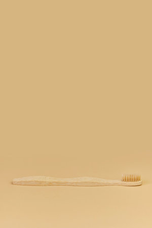 Single Bamboo wooden toothbrushe on beige background.の写真素材