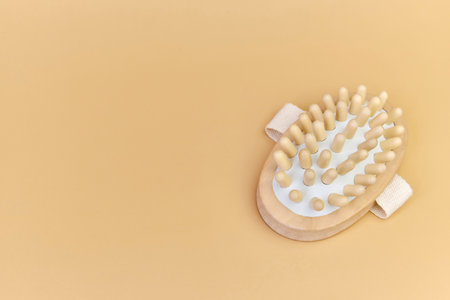 wooden massage brush with natural bristles on beige backgroundの写真素材