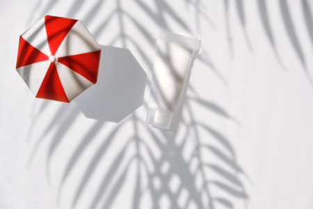 white water background with floral palm shadow and toy umbrella.の写真素材