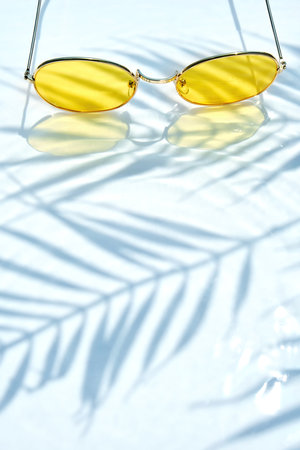 Summer flat lay with yellow sunglasses on water backgroundの写真素材